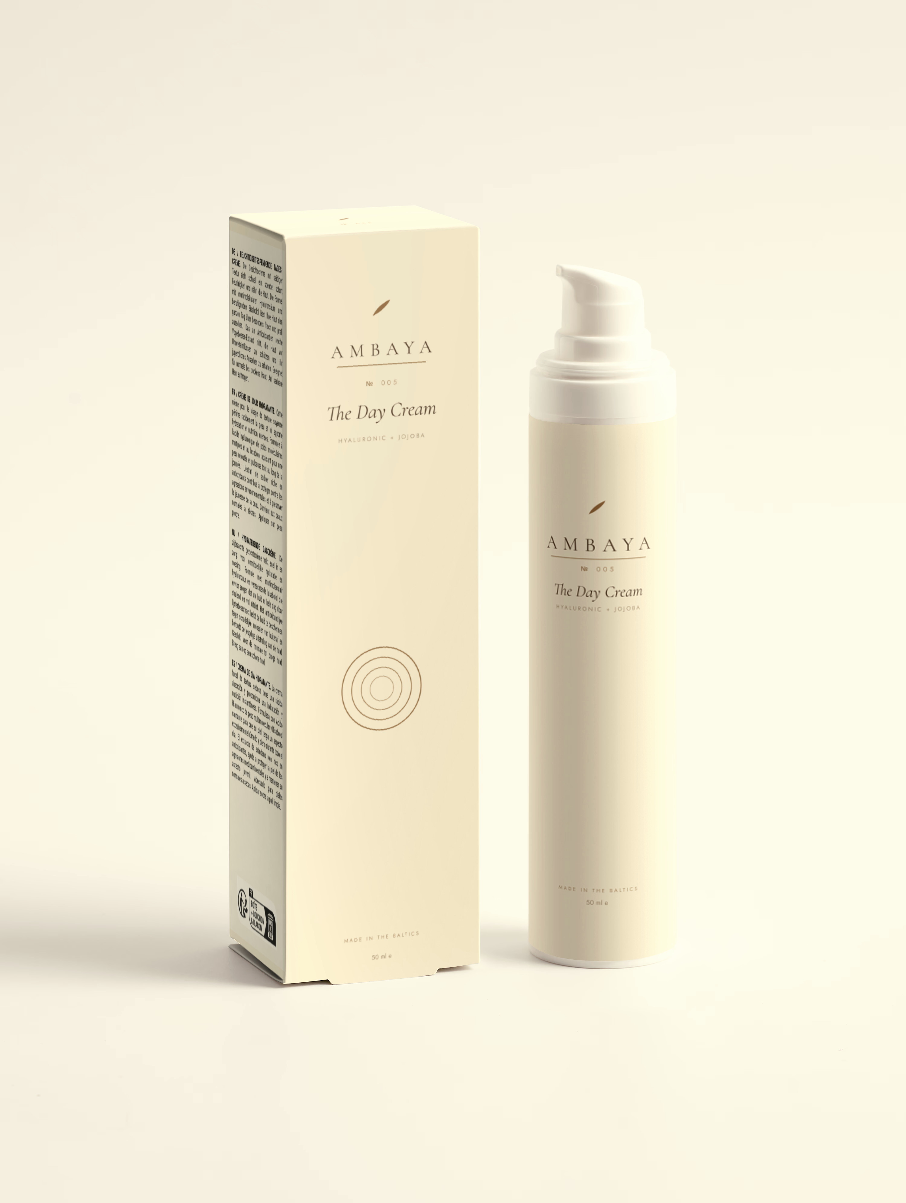Cream carton and airless pump bottle of The Day Cream, 50 ml, with the gold AMBAYA wordmark and leaf mark, on a pale cream background.