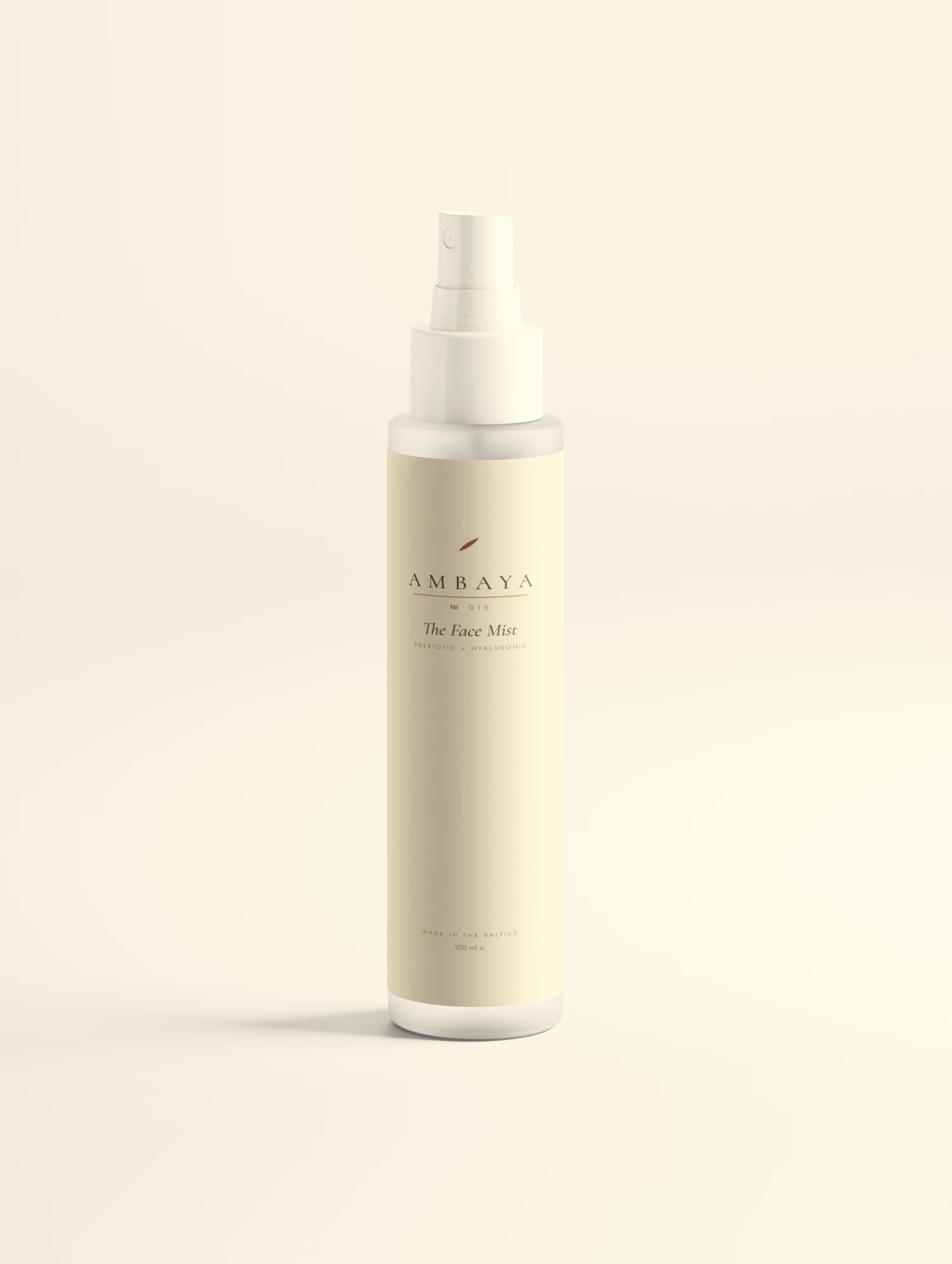Frosted spray bottle of The Face Mist, 100 ml, with a cream label carrying the gold AMBAYA wordmark, on a pale cream background.
